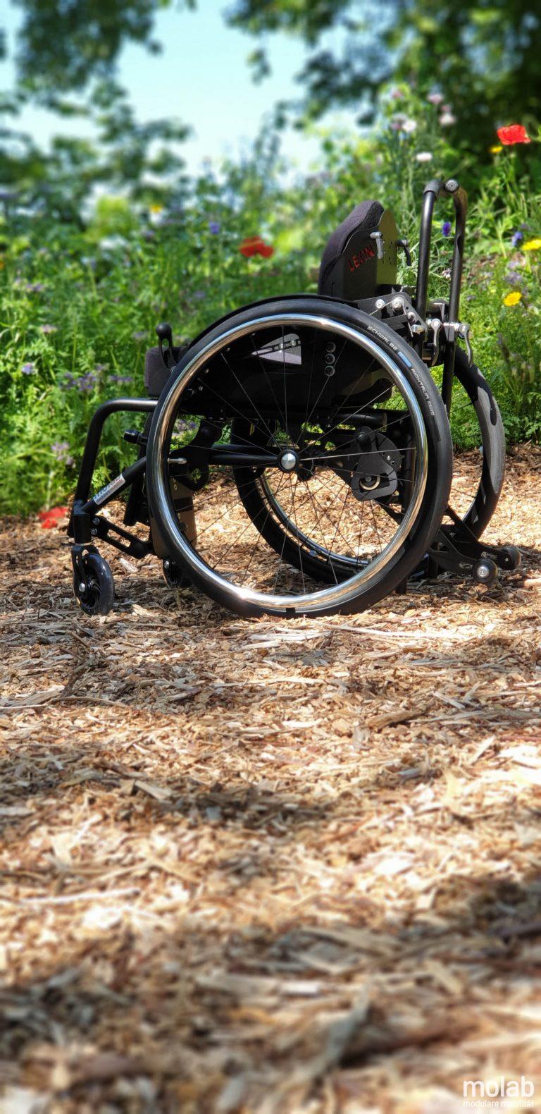 Molab G6KID Rollstuhl im Garten auf Rindenmulch.