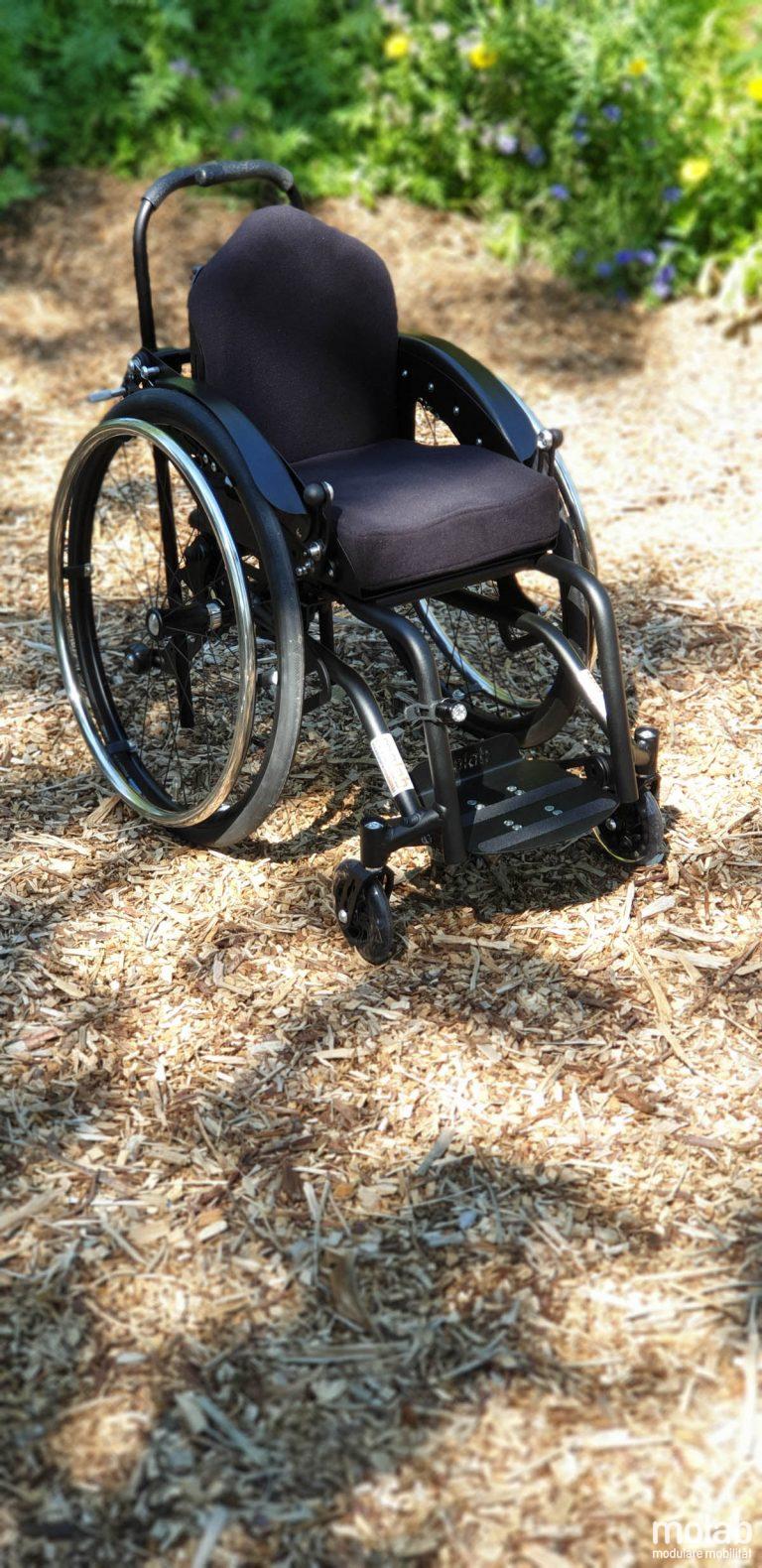 Molab G6KID Rollstuhl im Garten auf Rindenmulch.