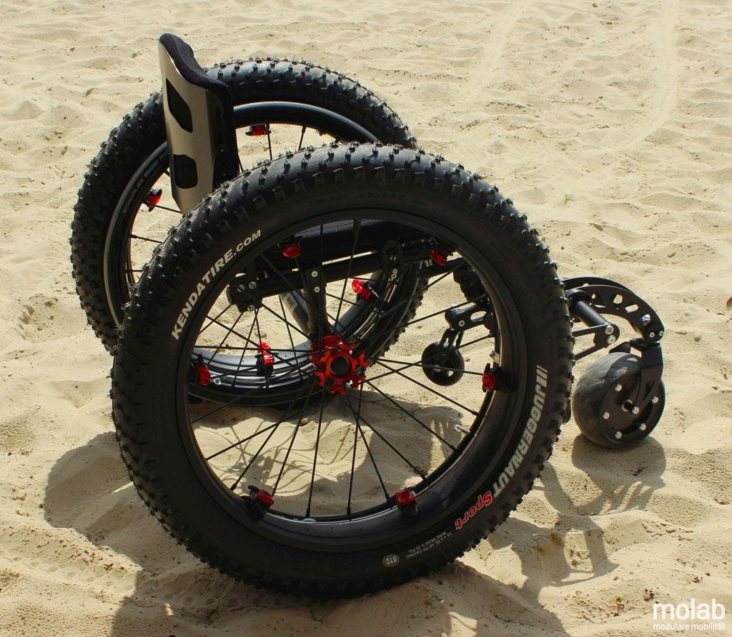 Straponwheelz mit Smartwheel montiert an einem leeren Rollstuhl stehend im Sand
