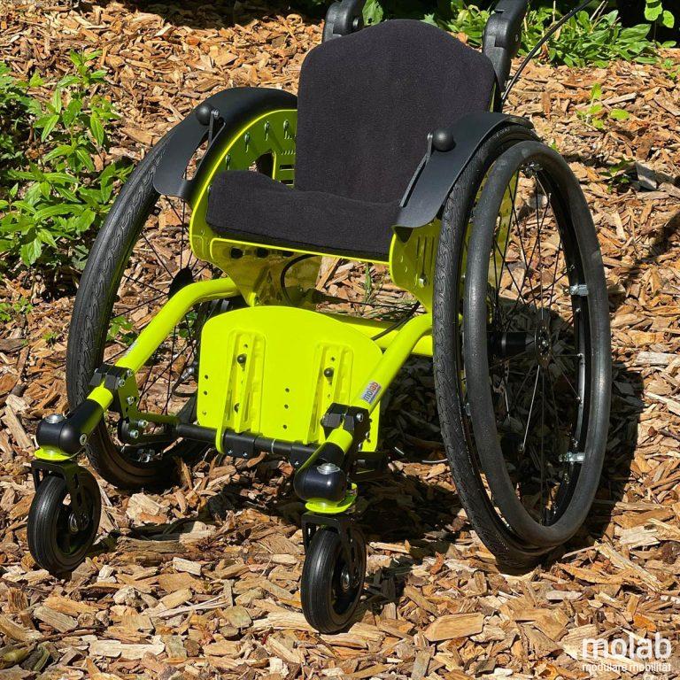 molab LOX Rollstuhl Vorderansicht Fußbrett hochgeklappt im Garten auf Rindenmulch.